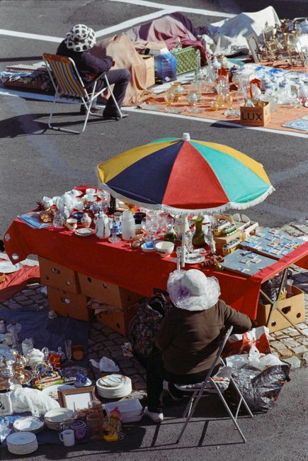 A large pile of crushed and crumpled aluminium beverage cans, mainly in silver, with some displaying identifiable branding such as red Coca-Cola logos and various colorful labels. The cans vary in siz